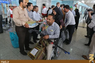 ورود زايران جانباز به مدينه منوره   استقبال با شاخه هاي گل 